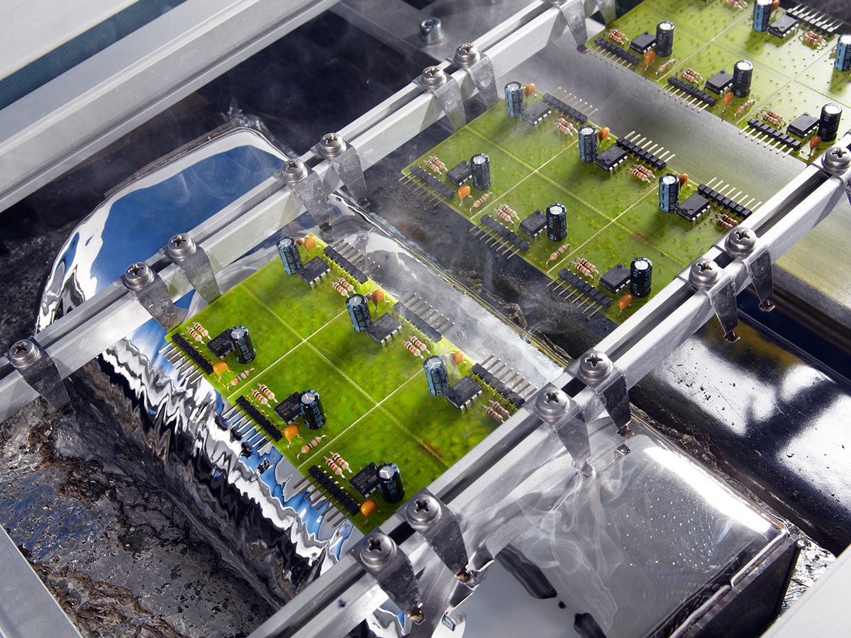 electronic assemblies in a wave soldering machine