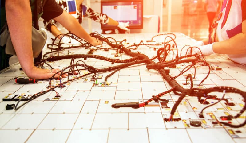 Hands of employees who check the quality of the wiring for cars Kabel- en bedradingstechnieken